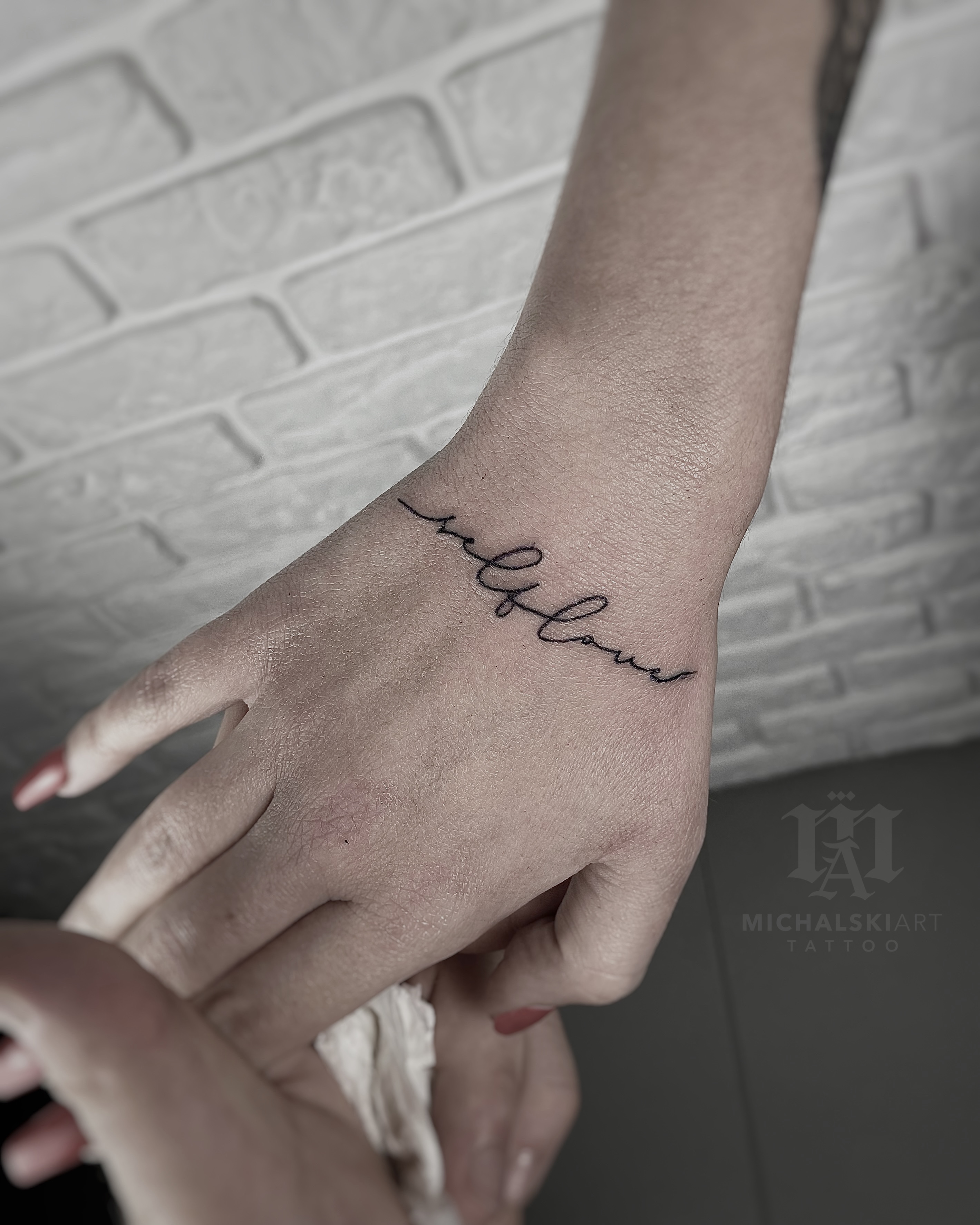 minimalistyczny tatuaż napis